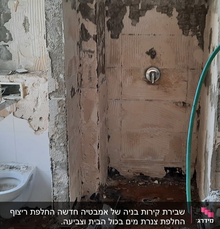 חדר אמבטיה בשיפוץ עם קירות חשופים וצנרת גלויה
